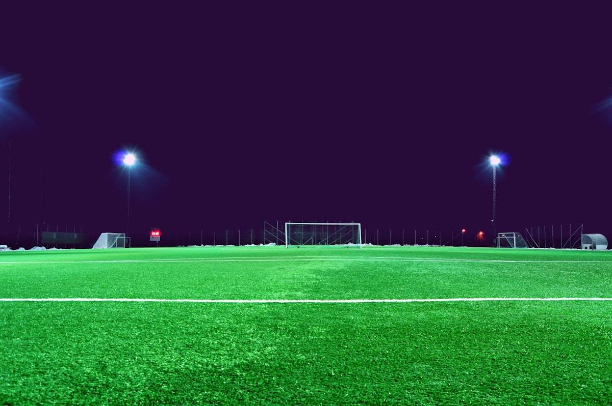 Stadion sepak bola dengan lampu sorot menyala di malam hari